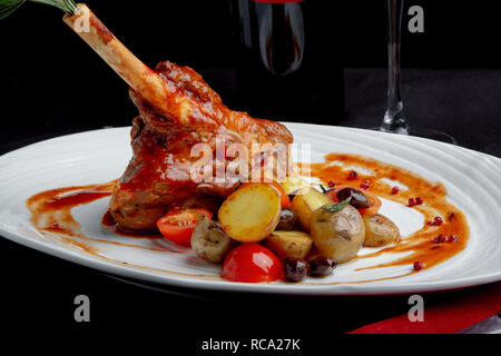 delicious restaurant dish, rack of lamb in restaurant background. Healthy exclusive food on big white platter closeup Stock Photo