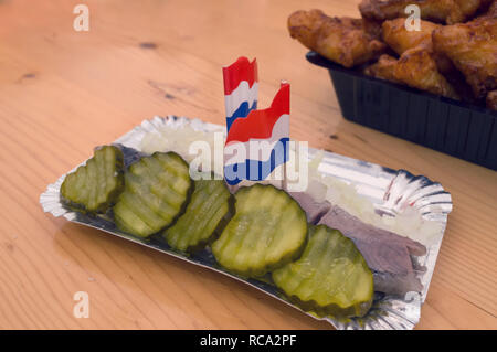 close up view of famous holland meal - marinated herring served with pickled cucumbers and chopped onion Stock Photo