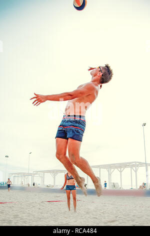 Volleyball beach player is a male athlete volleyball player getting ready to serve the ball on the beach. Stock Photo