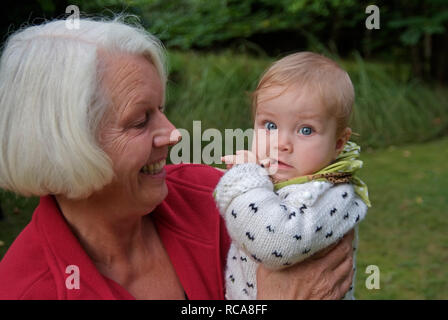 Oma hat Enkelkind im Arm | Grandmother carries her granddaughter on her arm Stock Photo