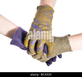 gloved hand covers handshake of two hands in colored gloves isolated on white background Stock Photo