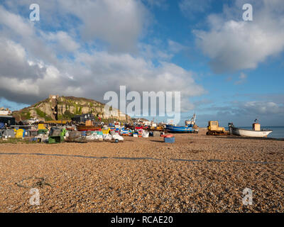 Commercial fishing boats on the shingle beach at at dusk at Hastings East Sussex UK, the biggest beach launched inshore fishing fleet in Europe Stock Photo