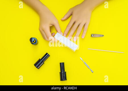 Woman Hands Care. Top View Of Beautiful Smooth Woman's Hands With Professional Nail Care Tools For Manicure On yellow Background. Closeup Of Healthy Female Nails With yellow Nail Polish. High Resolution Stock Photo
