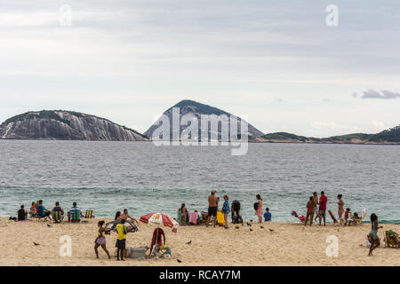 2019, january. Rio de Janeiro, Brazil. People on the beach, in Coacabana, in front of some rocky islands. Stock Photo