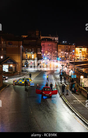 Ramsgate bomb suspected bomb incident on 14 January 2019. Police cars with blue flashing lights help cordon off the harbour road, night time. Three police cars and some policemen parked on approach road to seafront and harbour. 'Police slow' sign. Car stopped people outside talking. Stock Photo
