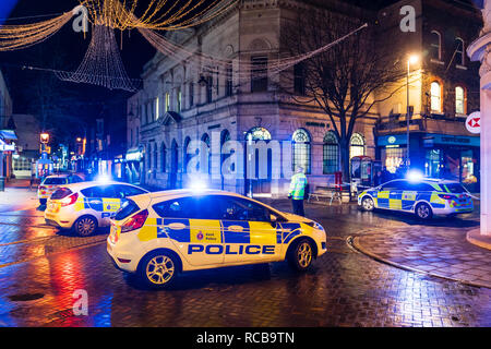 Ramsgate bomb suspected bomb incident on 14 January 2019. Police cars with blue flashing lights help cordon off the town centre, night time. Three police cars and some policemen parked on cross roads on town, city street. Stock Photo