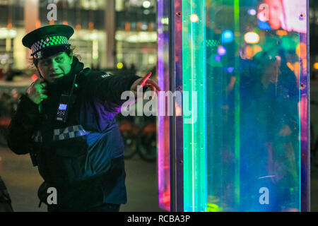 Canary Wharf, London, UK, 14th Jan 2019. People look at the revolving columns of the 'Prismatica' installation in Jubilee Square. The colourful Canary Wharf Winter Lights installations once again open to public viewing and interactive fun in and around Canary Wharf from Jan 15th until Jan 26th. Credit: Imageplotter News and Sports/Alamy Live News Stock Photo