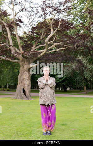 Young woman meditating in park Stock Photo