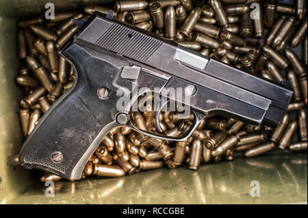 Top view of gun and ammunition box on the table. Bullets for pistol in shooting range Stock Photo