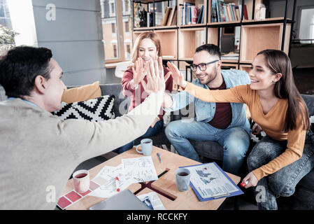 Cheerful team giving a high-five Stock Photo