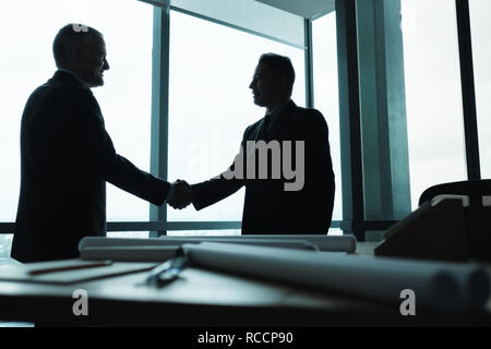 Manager Shaking Hands of Business Partner In Meeting Room Stock Photo