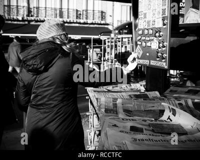 LISBON, PORTUGAL - FEB 10, 2018: Woman receiving change at press kiosk after buying fresh newspaper in central Lisbon black and white picture  Stock Photo