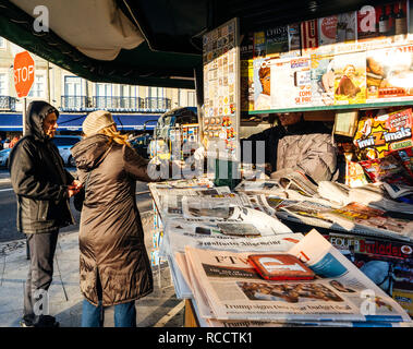 LISBON, PORTUGAL - FEB 10, 2018: Couple receiving change at press kiosk after buying fresh newspaper in central Lisbon  Stock Photo