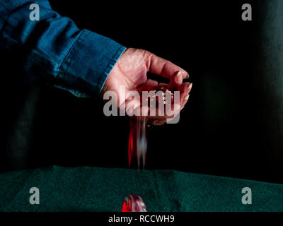 The hand of a person throwing the dice on a green carpet Stock Photo