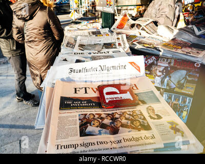 LISBON, PORTUGAL - FEB 10, 2018: People buying Frankfurter Allgemeine Zeitung and Financial Times Weekend newspaper on kiosk in central Lisbon with headline of Trump signing two-year budget deal  Stock Photo