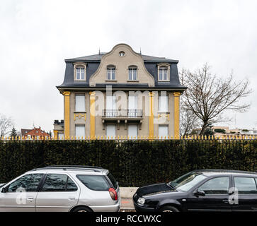 PARIS, FRANCE - MAR 15, 2018: Luxury house with golden pillars view from the street with two parked cars  Stock Photo
