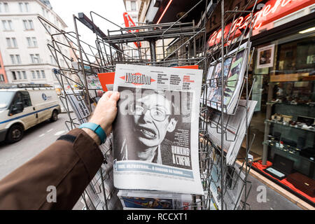 PARIS, FRANCE - MAR 15, 2018: Man buying French Liberation newspaper with portrait of Stephen Hawking the English theoretical physicist, cosmologist dead on 14 March 2018 Stock Photo