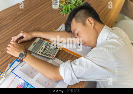 Asian man sleeping on working desk Stock Photo