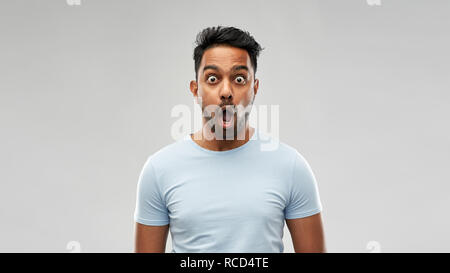 shocked or scared man over grey background Stock Photo