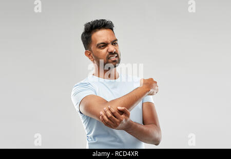 unhappy man suffering from pain in hand Stock Photo