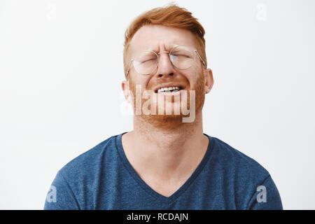 Indoor shot of gloomy and upset redhead mature man with beard, tilting head behind, frowning and grimacing, complaining to friend on bad life, whining or crying heart out in despair Stock Photo