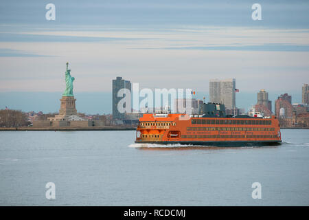 The MV Andrew J. Barberi Staten Island Ferry passes the statue of liberty as it travels from Manhattan to Staten Island in New York, New York City, NY Stock Photo