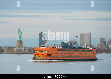 The MV Andrew J. Barberi Staten Island Ferry passes the statue of liberty as it travels from Manhattan to Staten Island in New York, New York City, NY Stock Photo