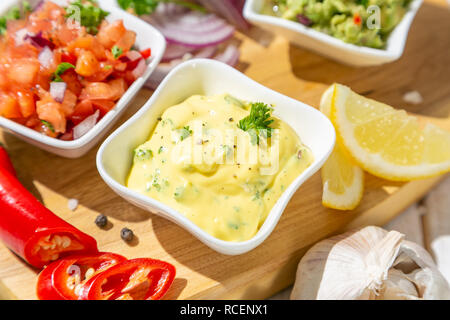 Selection of mexican sauces - salsa, guacamole, cheese sauce and ingredients, white wood background Stock Photo