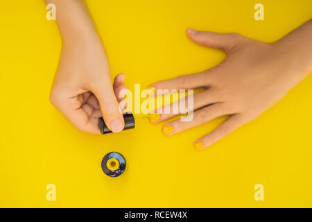 Woman Hands Care. Top View Of Beautiful Smooth Woman's Hands With Professional Nail Care Tools For Manicure On yellow Background. Closeup Of Healthy Female Nails With yellow Nail Polish. High Resolution