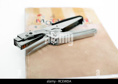 Stapler on the diary. Isolated on the white background. Stock Photo