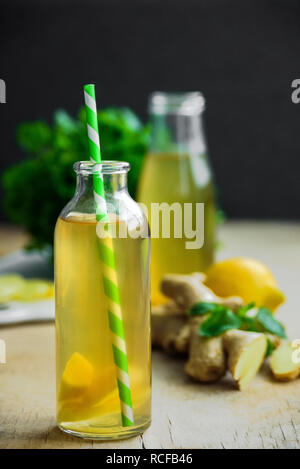 Bottle of detox ginger water on wooden background. Ingredients ginger, lemon, mint. Dieting concept. Stock Photo