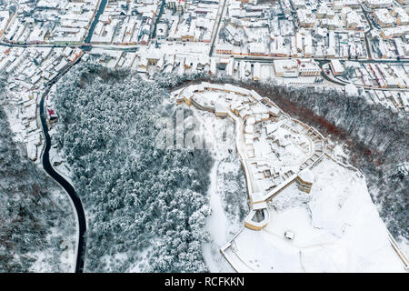 Rasnov Fortress and Rasnov City in winter time covered in snow Stock Photo