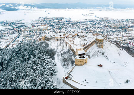 Winter at Rasnov Fortress with the Rasnov City visible in the Background Stock Photo