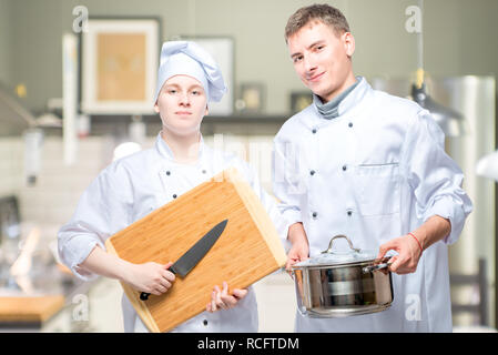 professional cooks with kitchen utensils in the kitchen of the restaurant Stock Photo