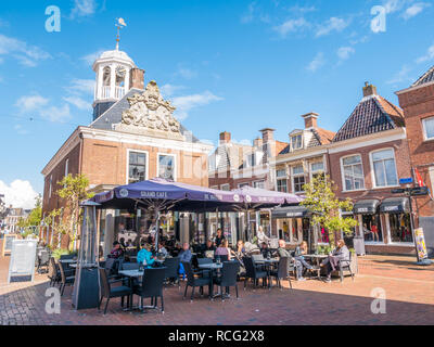 People relaxing on outdoor terrace of grand cafe in historic weigh house in old town of Dokkum, Friesland, Netherlands Stock Photo