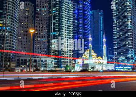 Mohammed Bin Ahmed Almulla mosque with buidings and light trails at night in Dubai, United Arab Emirates Stock Photo
