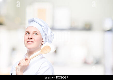 portrait of a happy dreaming cook with a wooden spoon, a place for an inscription on the right Stock Photo