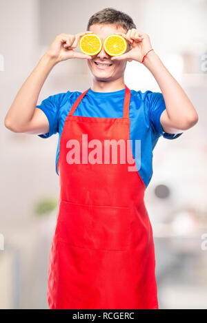 man in an apron fun photo with oranges in the kitchen Stock Photo