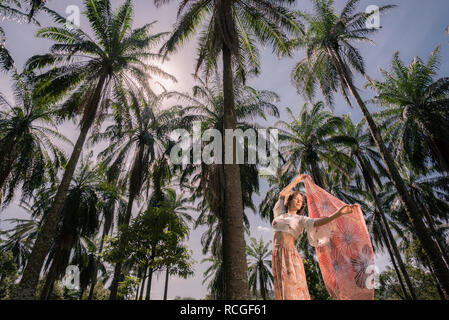 Solo Caucasian female traveler alone amidst Palm Trees in Putrajaya, Malaysia Stock Photo