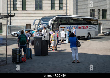 Passengers board a National Express coach in Brighton, UK. Stock Photo