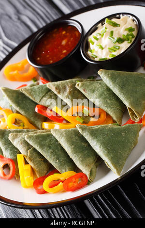 Vegetarian Spinach samosa with sauces close-up on a plate on the table. vertical Stock Photo