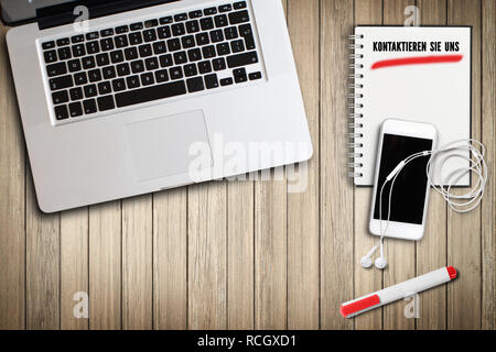 note pad with message "contact us" at a digital computer workplace on wooden background Stock Photo