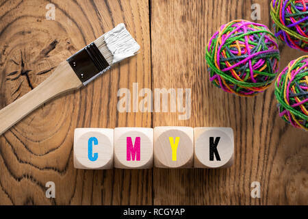 cubes with colored letters for CMYK on wooden background Stock Photo
