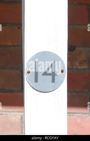 House number 14 sign on wooden post Stock Photo