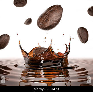 Some Coffee beans falling, one is splashing in a pool of coffee with crown splash. Isolated on white background. Stock Photo