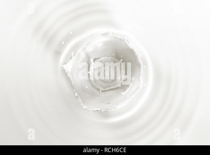 Milk double crown splash, splashing in milk pool with ripples. Viewed from the top. Stock Photo