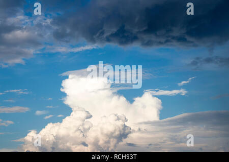 Cloudy sky: Contrast of fluffy bright and dark rainy clouds show quick weather change during strong wind Stock Photo