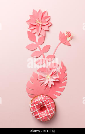 Handcraft plant corner from live coral paper with tropical leaf and donut.  A modern handmade paper application from colored paper on pink background. Stock Photo