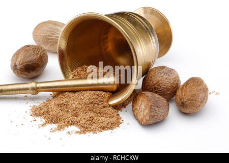 Nutmegs and nutmeg powder in bronze bowl isolated on white background Stock Photo