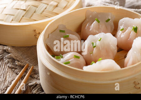 Chinese dumplings served on the traditional steamer. rustic background. horizontal Stock Photo